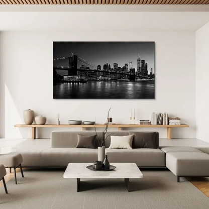 Illuminated Brooklyn Bridge spanning the East River in a monochrome cityscape.