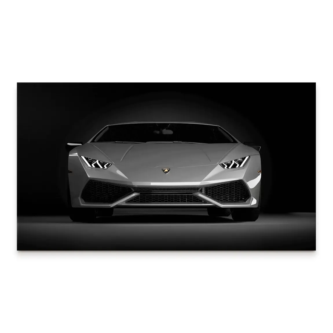 Front-on grayscale Lamborghini Huracan canvas print with a dark background and bright LED headlights.