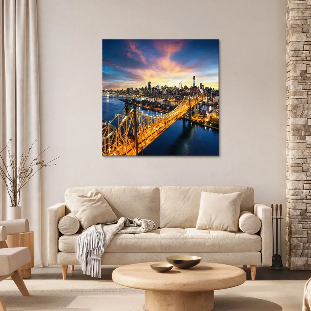 Warm golden lights along the bridge reflecting on deep blue water with skyline backdrop