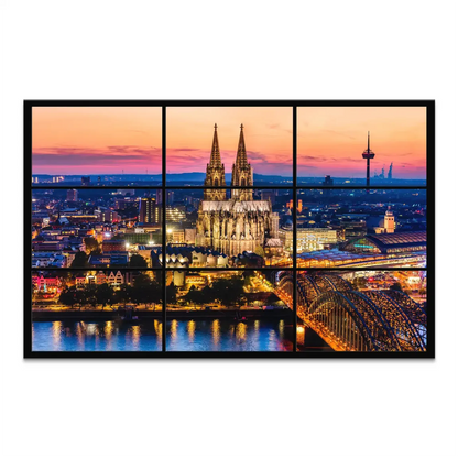 Cologne Cathedral illuminated at dusk with a vibrant sunset over the skyline