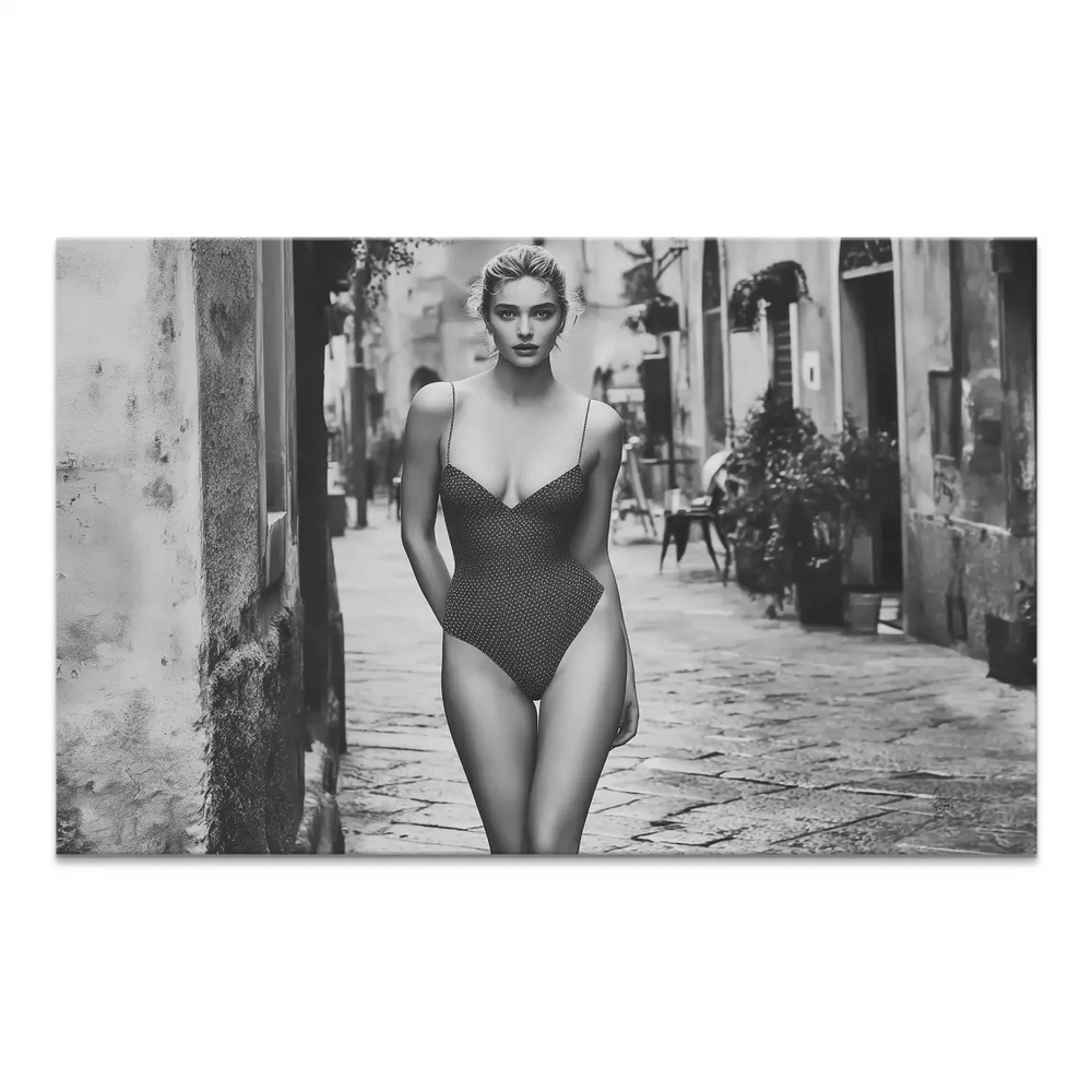 Black-and-white photo of a stylish woman walking in a narrow Italian alley.