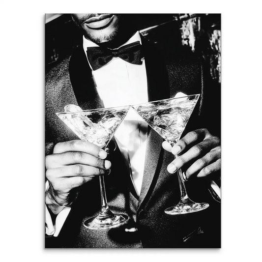 High-contrast black-and-white portrait of a man in a tuxedo holding two martini glasses filled with ice