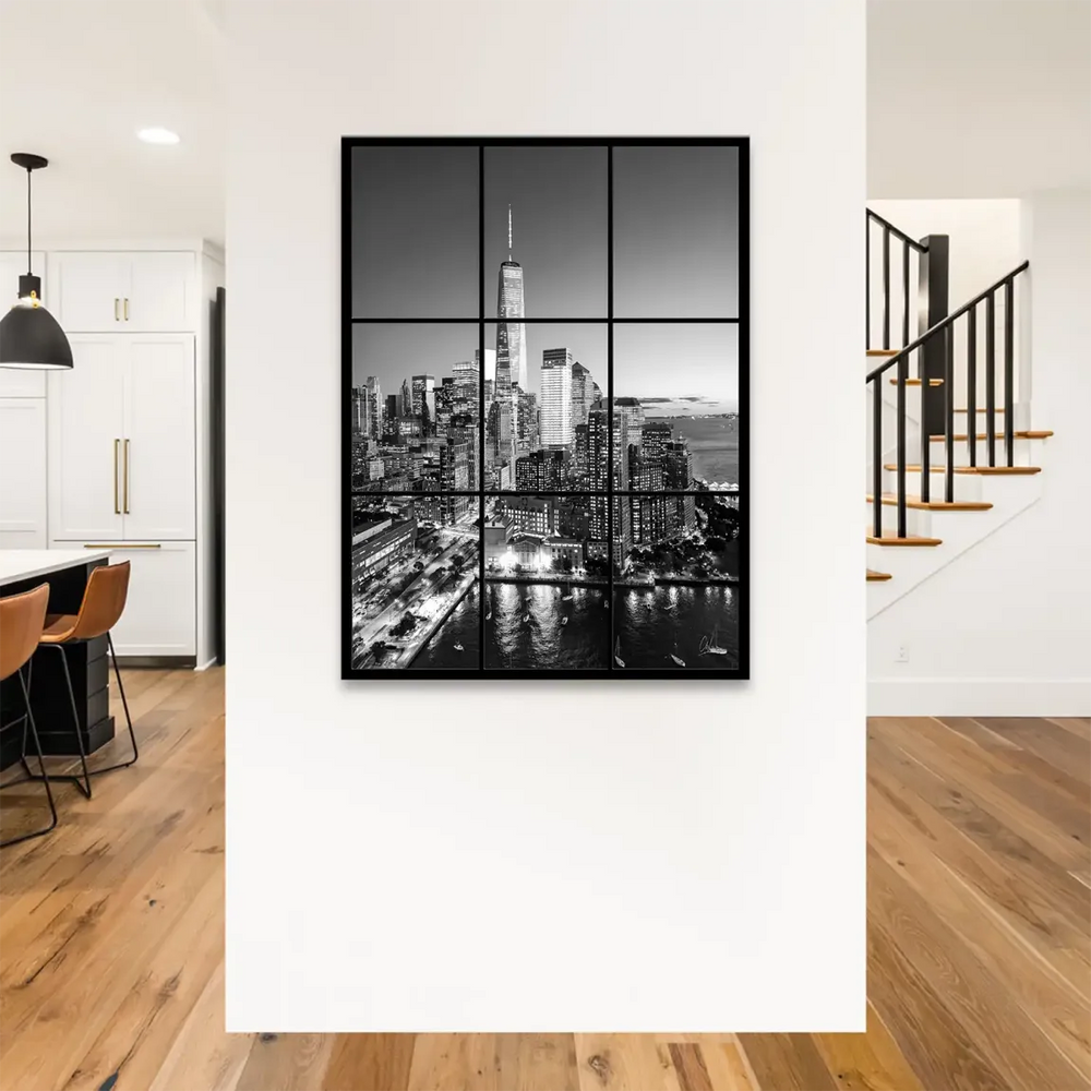 Skyscrapers illuminated at night behind a nine-pane window frame