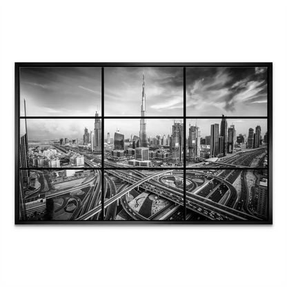 Silhouette of Burj Khalifa rising above clustered skyscrapers in grayscale