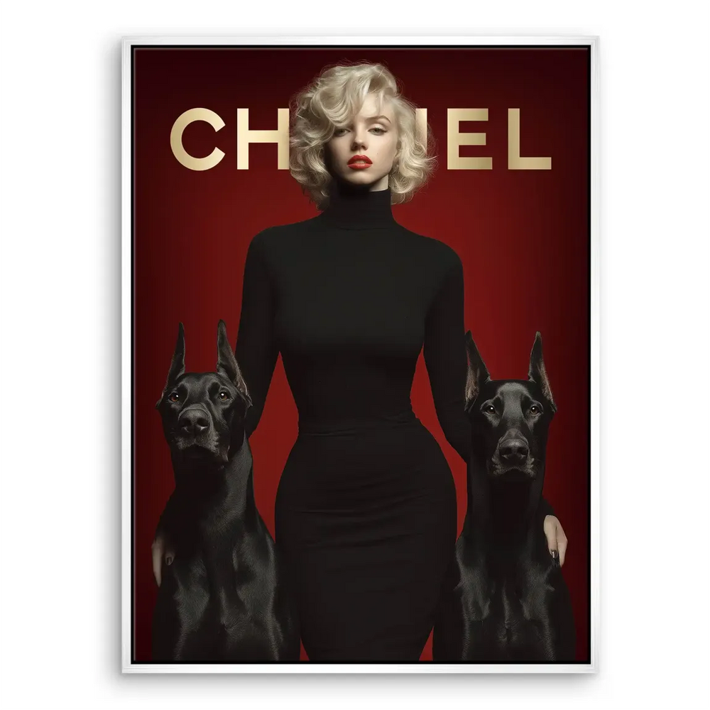 Two black Dobermans flanking a chic woman in black with red background and gold CHANEL branding